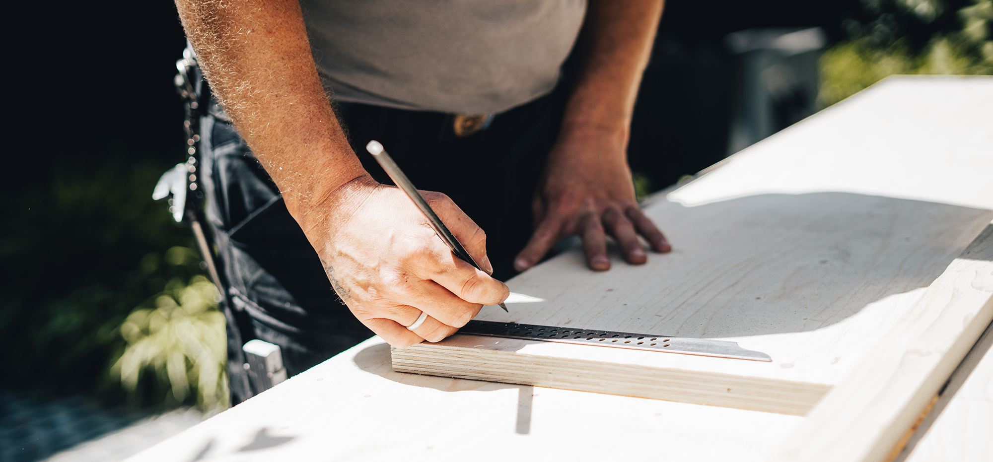 Handwerker zeichnet die Planung einer Holzkonstruktion auf Papier